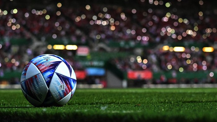 The match ball is pictured as fans use their phone lights during a partial electricty black out causing a delay to the kick-off of the UEFA Nations League the UEFA Nations League football match Austria v Denmark in Vienna, Austria on June 6, 2022. (Photo by JOE KLAMAR / AFP)