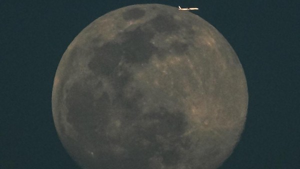 Berikutnya sebuah pesawat komersil di langit Kuwait nampak mengelilingi bulan purnama. (Yasser Al-Zayyat/AFP/Getty Images). Berikutnya sebuah pesawat komersil di langit Kuwait nampak mengelilingi bulan purnama. (Yasser Al-Zayyat/AFP/Getty Images).