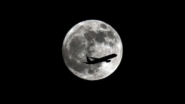 Pertama, ada siluet pesawat saat melintasi langit California, Amerika Serikat, saat momen purnama stroberi bulan Juni 2022 lalu. (Nick Ut/Getty Images). Pertama, ada siluet pesawat saat melintasi langit California, Amerika Serikat, saat momen purnama stroberi bulan Juni 2022 lalu. (Nick Ut/Getty Images).