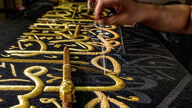 An embroiderer sews with gold thread a verse from the Holy Koran, Islam's holy book, onto a replica of the Kiswa, the cloth used to cover the Kaaba at the Grand Mosque in the Muslim holy city of Mecca, to be sold as a souvenir for tourists visiting the historic district of al-Hussein of Islamic Cairo in Egypt's capital on June 15, 2022. - From the 13th century, Egyptian artisans made the giant cloth in sections, which authorities transported to Mecca with great ceremony. Celebrations would mark processions through cities, flanked by guards and clergymen as Egyptians sprinkled rosewater from balconies above. From 1927, manufacturing began to move to Mecca in the nascent Kingdom of Saudi Arabia, which would fully take over production of the kiswa in 1962. (Photo by Khaled DESOUKI / AFP) (Photo by KHALED DESOUKI/AFP via Getty Images)