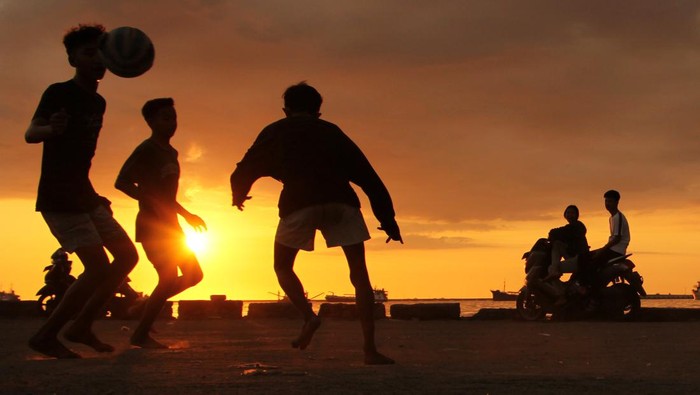 Menatap Syahdu Pedar Senja di Pelabuhan Rakyat Paotere Sejumlah remaja bermain bola dengan latar belakang pemandangan matahari terbenam di Pelabuhan Rakyat Paotere, Makassar, Sulawesi Selatan, Selasa (5/7/2022). Pelabuhan tersebut ramai dikunjungi warga terutama para remaja dan anak-anak untuk menikmati panorama matahari terbenam. ANTARA FOTO/Arnas Padda/aww.