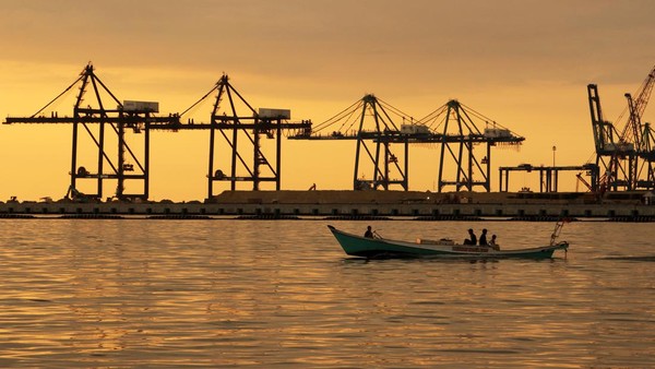 Nelayan menaiki perahu di dekat proyek pembangunan Makassar New Port (MNP) di Makassar, Sulawesi Selatan, Selasa (5/7/2022).  