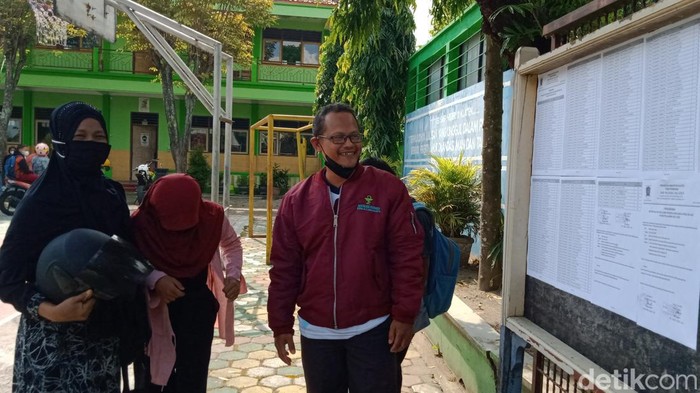 Orang tua anak kembar dampit melihat pengumuman di SMPN 3 Klaten, Rabu (6/7/2022).