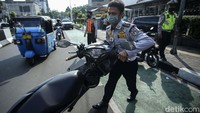 Petugas mengangkut sepeda motor karena parkir sembarangan.
