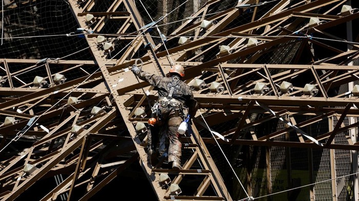 Penampakan Menara Eiffel Penuh Karat, Tapi Cuma Dicat Ulang A worker is seen on the Eiffel tower during the 20th campaign of painting and stripping of the Eiffel tower in Paris, France, July 5, 2022. REUTERS/Benoit Tessier     TPX IMAGES OF THE DAY