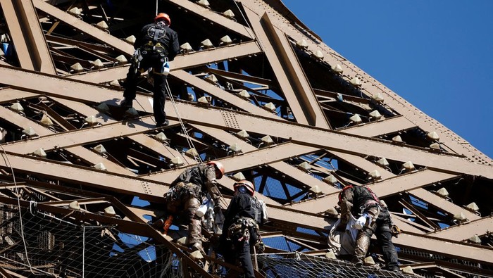 Penampakan Menara Eiffel Penuh Karat, Tapi Cuma Dicat Ulang A worker is seen on the Eiffel tower during the 20th campaign of painting and stripping of the Eiffel tower in Paris, France, July 5, 2022. REUTERS/Benoit Tessier     TPX IMAGES OF THE DAY