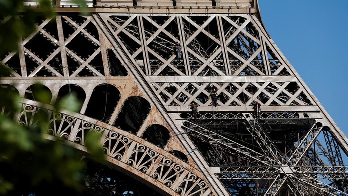 Penampakan Menara Eiffel Penuh Karat, Tapi Cuma Dicat Ulang A worker is seen on the Eiffel tower during the 20th campaign of painting and stripping of the Eiffel tower in Paris, France, July 5, 2022. REUTERS/Benoit Tessier     TPX IMAGES OF THE DAY