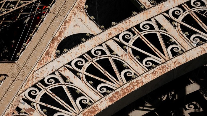 Penampakan Menara Eiffel Penuh Karat, Tapi Cuma Dicat Ulang A worker is seen on the Eiffel tower during the 20th campaign of painting and stripping of the Eiffel tower in Paris, France, July 5, 2022. REUTERS/Benoit Tessier TPX IMAGES OF THE DAY