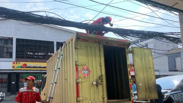 Petugas PT Telkom merapikan kabel yang semrawut di Jl Pecenongan Gambir, Jakarta Pusat, Rabu (6/7/2022).