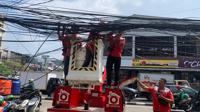 Petugas PT Telkom merapikan kabel yang semrawut di Jl Pecenongan Gambir, Jakarta Pusat, Rabu (6/7/2022).