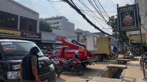 Petugas PT Telkom merapikan kabel yang semrawut di Jl Pecenongan Gambir, Jakarta Pusat, Rabu (6/7/2022).