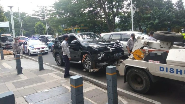 Polda Metro Jaya dan Dishub DKI menderek mobil yang parkir sembarangan di Jl Senopati, Jaksel.
