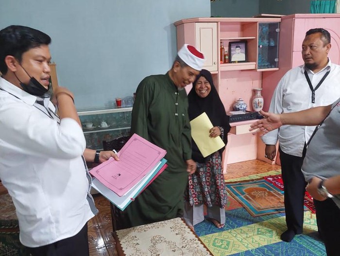 AB dan istri terlihat senyum-senyum saat dijemput polisi di rumahnya. (dok. Humas Polda Lampung)