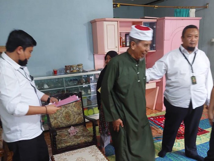 AB dijemput 3 orang polisi. AB terlihat cengar-cengir saat akan dibawa ke kantor polisi. (dok. Humas Polda Lampung)