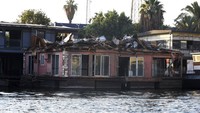 Sebuah rumah perahu yang dibongkar sebagian berada di tepi Sungai Nil setelah dipindahkan dari tambatannya di Kairo, Mesir, Jumat (1/7/2022).  
