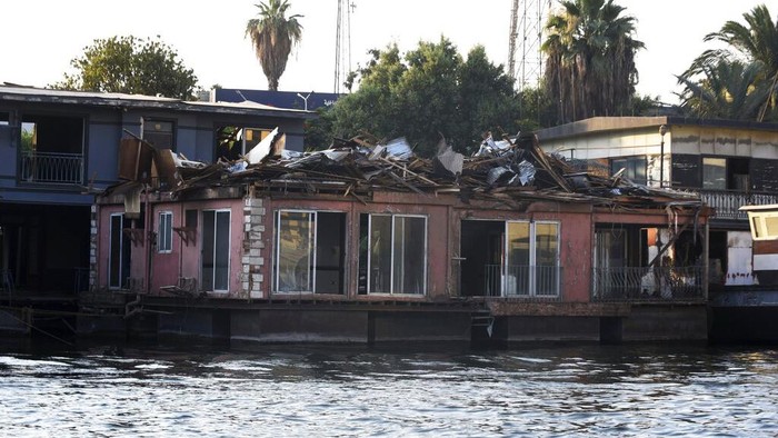 Rumah Perahu Ikonik di Mesir Akan Musnah dari Sungai Nil The houseboat belonging to Ikhlas Helmy is seen from the other side of the River Nile on June 27, 2022. A government push to remove the string of houseboats from Cairoβs Nile banks has dwindled their numbers from a several dozen to just a handful. Helmy stands to evicted, and the boat moved or demolished. The tradition of living on the Nile River dates back to the 1800s, and the removal of the boats has drawn criticism in Egypt. The government says it plans to develop the waterfront. (AP Photo/Tarek Wagih)