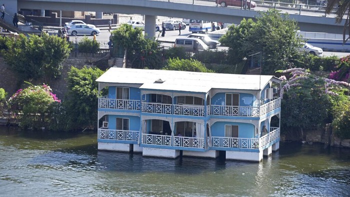 Rumah Perahu Ikonik di Mesir Akan Musnah dari Sungai Nil The houseboat belonging to Ikhlas Helmy is seen from the other side of the River Nile on June 27, 2022. A government push to remove the string of houseboats from Cairoβs Nile banks has dwindled their numbers from a several dozen to just a handful. Helmy stands to evicted, and the boat moved or demolished. The tradition of living on the Nile River dates back to the 1800s, and the removal of the boats has drawn criticism in Egypt. The government says it plans to develop the waterfront. (AP Photo/Tarek Wagih)