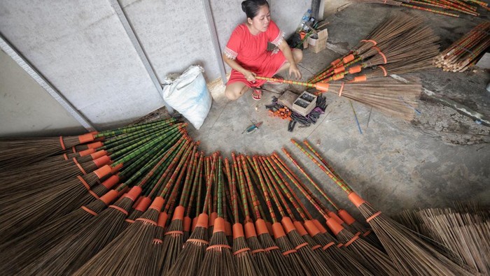 Perajin menyelesaikan pembuatan sapu lidi di Desa Karangsemanding, Gresik, Jawa Timur, Rabu (6/7/2022). Kerajinan sapu lidi berbahan daun kelapa tersebut dijual dengan harga Rp5.500 hingga Rp7 ribu per biji tergantung ukuran dan dikirim ke beberapa wilayah seperti Surabaya, Lamongan, Makassar, Sampit hingga Brunei Darussalam dan Timor Leste. ANTARA FOTO/Rizal Hanafi/Zk/foc.
