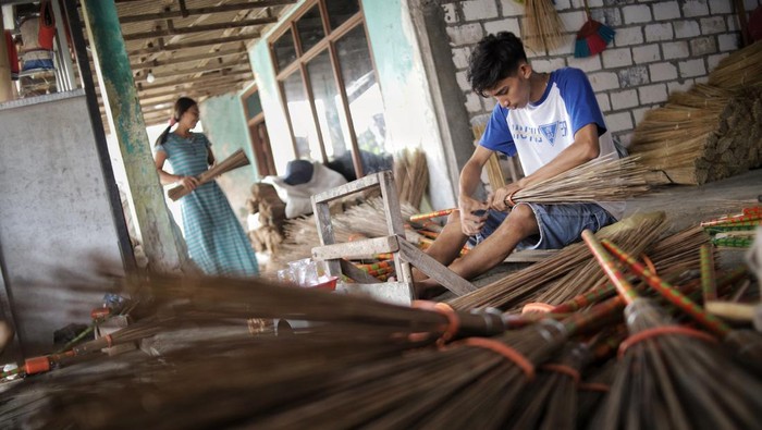 Perajin menyelesaikan pembuatan sapu lidi di Desa Karangsemanding, Gresik, Jawa Timur, Rabu (6/7/2022). Kerajinan sapu lidi berbahan daun kelapa tersebut dijual dengan harga Rp5.500 hingga Rp7 ribu per biji tergantung ukuran dan dikirim ke beberapa wilayah seperti Surabaya, Lamongan, Makassar, Sampit hingga Brunei Darussalam dan Timor Leste. ANTARA FOTO/Rizal Hanafi/Zk/foc.