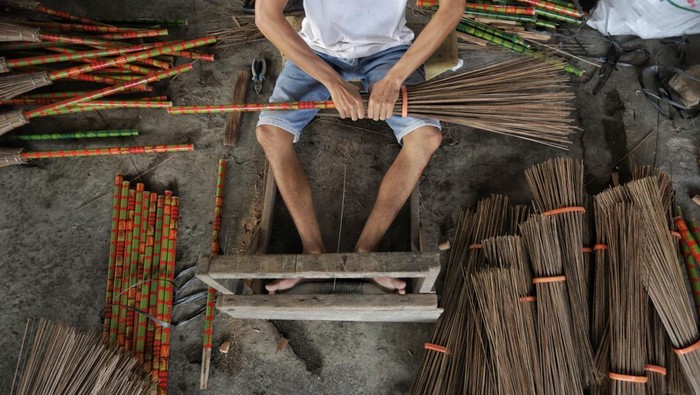 Sapu Lidi Asal Gresik Ini Tembus Pasar Pasar Internasional Perajin menyelesaikan pembuatan sapu lidi di Desa Karangsemanding, Gresik, Jawa Timur, Rabu (6/7/2022). Kerajinan sapu lidi berbahan daun kelapa tersebut dijual dengan harga Rp5.500 hingga Rp7 ribu per biji tergantung ukuran dan dikirim ke beberapa wilayah seperti Surabaya, Lamongan, Makassar, Sampit hingga Brunei Darussalam dan Timor Leste. ANTARA FOTO/Rizal Hanafi/Zk/foc.