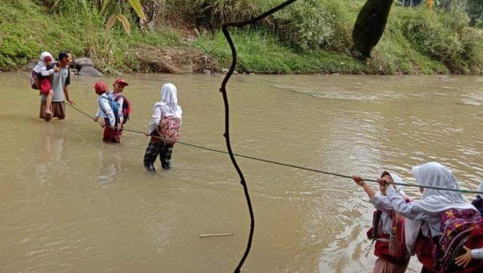 Sejumlah pelajar di Sukabumi sebrangi sungai.