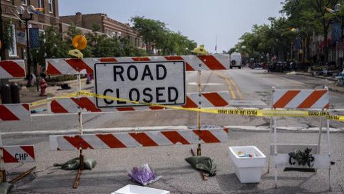 HIGHLAND PARK, IL - JULY 05: Flowers are laid near the scene of a shooting at a Fourth of July parade on July 5, 2022 in Highland Park, Illinois. Police have detained Robert Bobby E. Crimo III, 22, in connection with the shooting in which six people were killed and 19 injured, according to published reports.   Jim Vondruska/Getty Images/AFP (Photo by Jim Vondruska / GETTY IMAGES NORTH AMERICA / Getty Images via AFP)