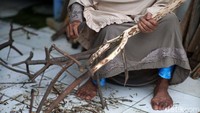 Perajin tengah menyelesaikan pembuatan hiasan bunga.