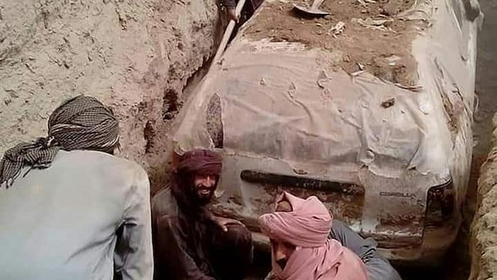 The white Toyota Corolla was buried in a village garden in Zabul province by Taliban official Abdul Jabbar Omari, who ordered it to be dug up this week. In this undated handout picture released by Taliban media officials on July 7, 2022, Taliban members dig up a Toyota Corolla, used by Taliban founder Mullah Omar to escape being targetted by US forces after 9/11, at Omrazai village in Seyora district of Zabul province.. Photo: Taliban media officials/AFP