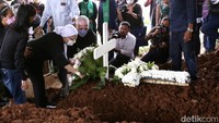 Sang istri, Rosmayati Nasution, mengawali penaburan bunga sebelum peti jenazah dikebumikan. Pool/Palevi S/detikFoto.
