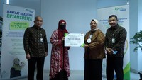 Direktur Pelayanan BPJAMSOSTEK Roswita Nilakurnia menyerahkan santunan kepada ahli waris peserta yang meninggal dunia karena kecelakaan kerja.
