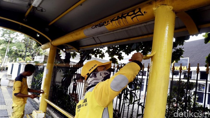 Petugas harian dari Sudin Bina Marga, Jakarta Selatan, tengah melakukan pengecatan ulang dengan cat baru di Halte Bus Melawai, Blok M, Jakarta, Rabu (07/07/2022).