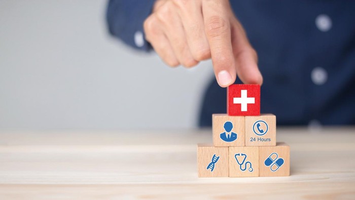 Hand arranging wood block stacking with icon healthcare medical, Health insurance - concept.