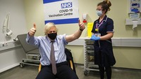 PM Boris Johnson mengacungkan kedua jempolnya saat disuntik vaksin Covid-19 di RS St.Thomas di London, Jumat (19/3/2021). Boris Johnson didesak mundur oleh para menteri dan pejabatnya. Setidaknya 50 menteri dan pejabat di kabinet Boris Johnson resign berjemaah hingga hari ini. (AP Photo/Frank Augstein)