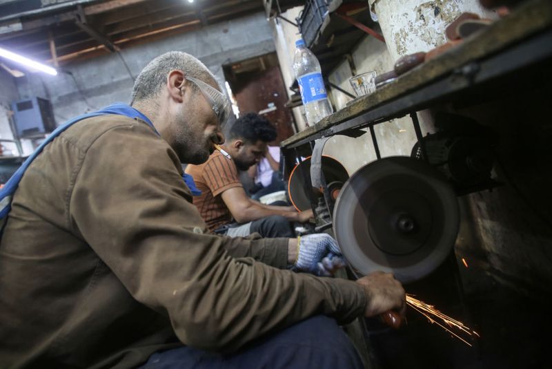 Palestinian workers sharp knives to be used to slaughter animals amidst preparations ahead of the Muslim pagelaran of Eid al-Adha in Gaza City on July 6, 2022. Known as the 
