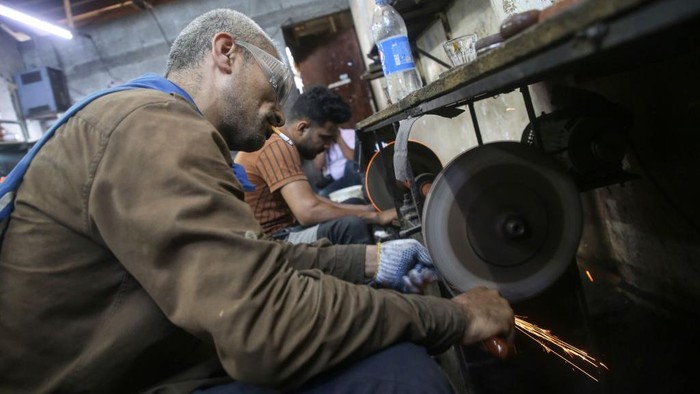 Palestinian workers sharp knives to be used to slaughter animals amidst preparations ahead of the Muslim festival of Eid al-Adha in Gaza City on July 6, 2022. Known as the 