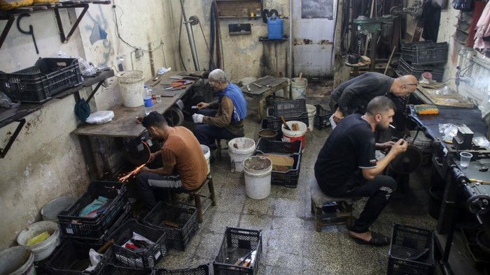 Melihat Kesibukan Tukang Asah Pisau Jelang Idul Adha di Gaza Palestinian workers sharp knives to be used to slaughter animals amidst preparations ahead of the Muslim festival of Eid al-Adha in Gaza City on July 6, 2022. Known as the
