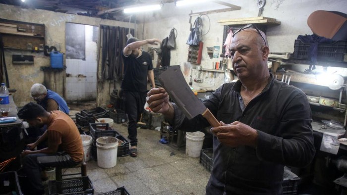 Melihat Kesibukan Tukang Asah Pisau Jelang Idul Adha di Gaza Palestinian workers sharp knives to be used to slaughter animals amidst preparations ahead of the Muslim festival of Eid al-Adha in Gaza City on July 6, 2022. Known as the