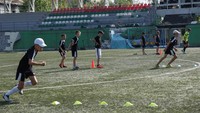 Sejumlah anak terlihat berlatih sepak bola di lapangan yang terdampak serangan bom Rusia.