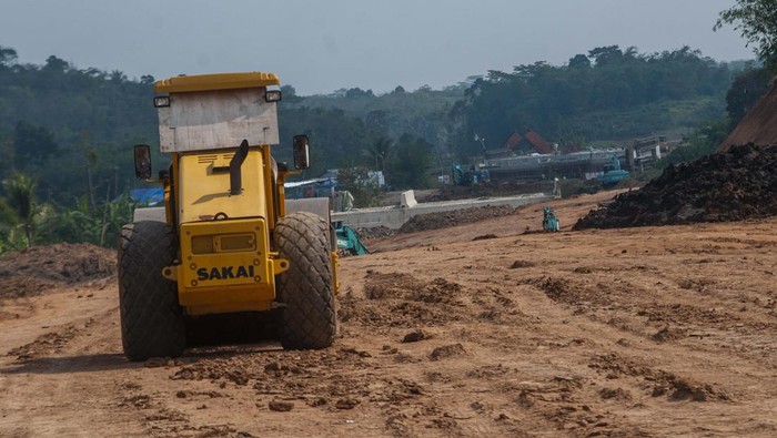 Pekerja menggunakan alat berat beraktivitas di proyek pembangunan jalan tol Rangkasbitung-Cileles di Cikulur, Lebak, Banten, Kamis (7/7/2022). Jalan tol Serang-Panimbang sepanjang 83,67 kilometer yang menjadi akses tercepat menuju Kawasan Ekonomi Khusus (KEK) Tanjung Lesung tersebut ditargetkan akan beroperasi pada tahun 2024 mendatang dan diharapkan dapat meningkatkan perekonomian masyarakat. ANTARA FOTO/Muhammad Bagus Khoirunas/hp.