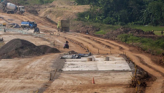 Pekerja menggunakan alat berat beraktivitas di proyek pembangunan jalan tol Rangkasbitung-Cileles di Cikulur, Lebak, Banten, Kamis (7/7/2022). Jalan tol Serang-Panimbang sepanjang 83,67 kilometer yang menjadi akses tercepat menuju Kawasan Ekonomi Khusus (KEK) Tanjung Lesung tersebut ditargetkan akan beroperasi pada tahun 2024 mendatang dan diharapkan dapat meningkatkan perekonomian masyarakat. ANTARA FOTO/Muhammad Bagus Khoirunas/hp.