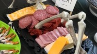 Daging tengkorak ini sebenarnya hanya cheese platter yang umum jadi cemilan. Tapi di tangan Linda, cheese platter ini tampak seram sekaligus lucu dengan kerangka tengkorak di atasnya. Foto: Facebook Cake Genus