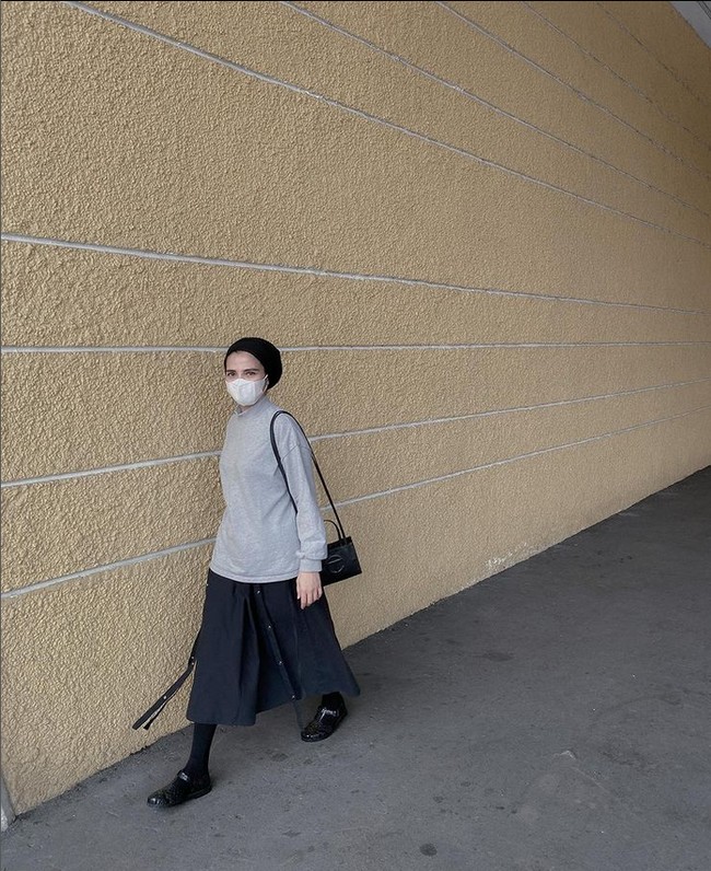 Gaya hijab Rosmanizar berubah pada 2021. Wanita yang mempunyai 132 ribu pengikut di Instagram ini tampil dengan hijab turban dan bergaya serba monokrom. Dalam foto ini, ia tampil simpel dan edgy dengan blouse abu-abu dan bawahan hitam. Foto: Dok. Instagram @rosmanizar12.