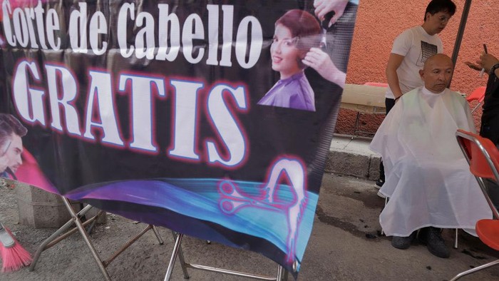 A person from Barrio San Juan del Pueblo San Francisco Culhuacán, in Mexico City, looks in the mirror after getting a free haircut as part of the activities organised by women in the area in conjunction with Mexico City authorities.

According to data from the National Institute of Statistics and Geography (INEGI), the majority of self-employed women work in the tertiary sector (81.2%) in commerce, restaurants and various services such as hairdressing, cosmetology and beauty salons. (Photo by Gerardo Vieyra/NurPhoto via Getty Images)