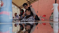 Seorang warga Meksiko sedang berdiskusi bersama seorang tukang cukur wanita saat hendak potong rambut, Rabu (6/7/2022).