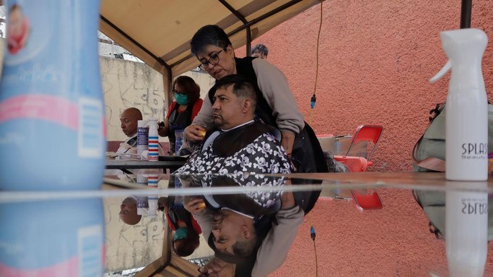Tukang Cukur Wanita di Meksiko Gratiskan Pangkas Rambut A person from Barrio San Juan del Pueblo San Francisco CulhuacΓ‘n, in Mexico City, looks in the mirror after getting a free haircut as part of the activities organised by women in the area in conjunction with Mexico City authorities.
According to data from the National Institute of Statistics and Geography (INEGI), the majority of self-employed women work in the tertiary sector (81.2%) in commerce, restaurants and various services such as hairdressing, cosmetology and beauty salons. (Photo by Gerardo Vieyra/NurPhoto via Getty Images)