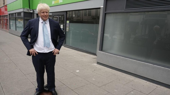 BLACKPOOL, ENGLAND - JULY 07: Locals pose with a waxwork of Boris Johnson in front of a job centre on July 7, 2022 in Blackpool, England. Shortly after news broke that the prime minister would resign, Madame Tussauds Blackpool brought its waxwork of the prime minister to Blackpool's Jobcentre Plus. (Photo by Christopher Furlong/Getty Images)