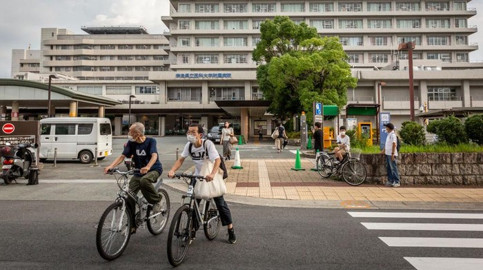 1407473529 NARA, JAPAN - JULY 09: People cycle past Nara Medical University Hospital where Japanβs former prime minister Shinzo Abe is transferred after being attacked during an election campaign on July 09, 2022 in Nara, Japan. Former Prime Minister Abe collapsed after shots were heard while he was campaigning at a rally. A suspect was apprehended and taken into custody, as Abe was rushed to a hospital via helicopter. (Photo by Yuichi Yamazaki/Getty Images)