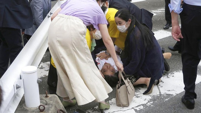 Japan’s former Prime Minister Shinzo Abe, center, falls on the ground in Nara, western Japan Friday, July 8, 2022. Abe was in heart failure after apparently being shot during a campaign speech Friday in western Japan, NHK public television said Friday. (Kyodo News via AP)