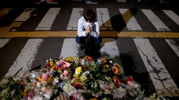 People lay flowers at the site where late former Japanese Prime Minister Shinzo Abe was shot while campaigning for a parliamentary election, near Yamato-Saidaiji station in Nara, western Japan, July 8, 2022. REUTERS/Issei Kato