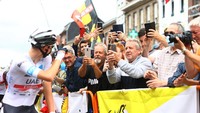 Pogacar tersenyum di depan penggemarnya sesaat sebelum start etape 6 TDF 2022. Pogacar merebut jersey kuning di etape ke-6. Hanya saja, posisi juara bertahan 2020 dan 2021 tersebut belum sepenuhnya aman. Ia ditempel oleh Neilson Powless dengan selisih waktu 4 detik.  (Michael Steele/Getty Images)
